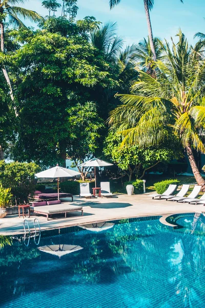 Güzel lüks otel ve tatil seyahat ve tatil için sandalye ve şemsiye ile açık yüzme havuzu