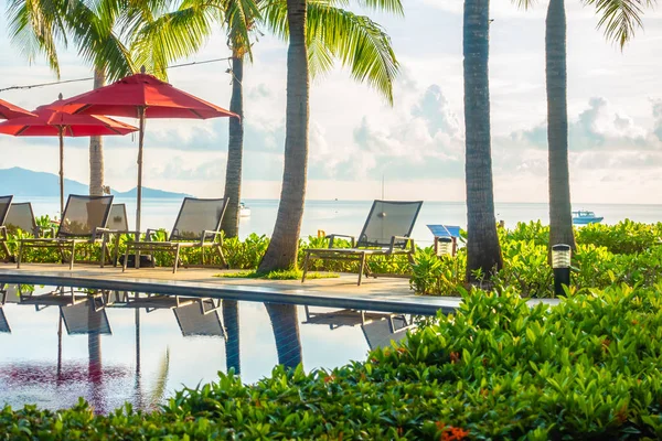 Güzel lüks otel ve tatil seyahat ve tatil için sandalye ve şemsiye ile açık yüzme havuzu