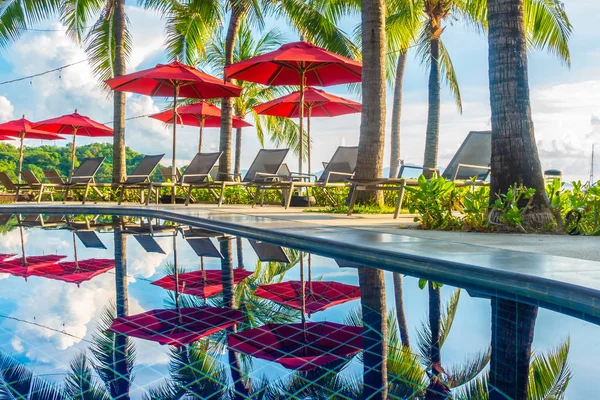 Güzel lüks otel ve tatil seyahat ve tatil için sandalye ve şemsiye ile açık yüzme havuzu