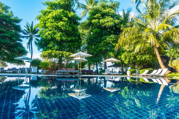 Güzel lüks otel ve tatil seyahat ve tatil için sandalye ve şemsiye ile açık yüzme havuzu