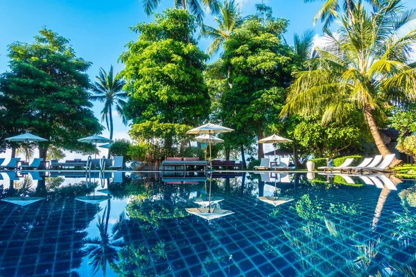 Güzel lüks otel ve tatil seyahat ve tatil için sandalye ve şemsiye ile açık yüzme havuzu