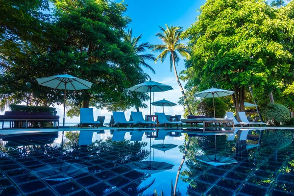 Güzel lüks otel ve tatil seyahat ve tatil için sandalye ve şemsiye ile açık yüzme havuzu