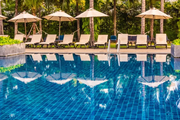Güzel lüks otel ve tatil seyahat ve tatil için sandalye ve şemsiye ile açık yüzme havuzu