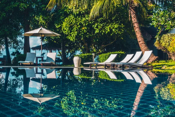 Güzel lüks otel ve tatil seyahat ve tatil için sandalye ve şemsiye ile açık yüzme havuzu