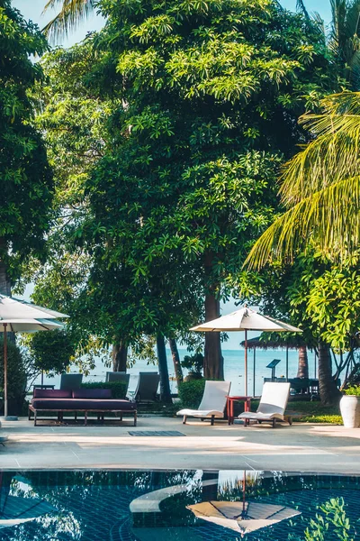 Güzel lüks otel ve tatil seyahat ve tatil için sandalye ve şemsiye ile açık yüzme havuzu