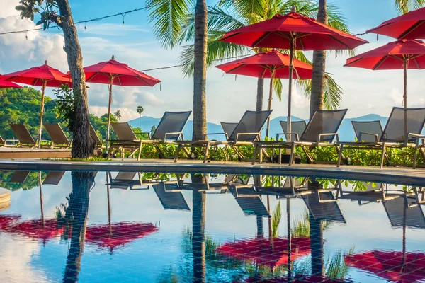 Güzel lüks otel ve tatil seyahat ve tatil için sandalye ve şemsiye ile açık yüzme havuzu