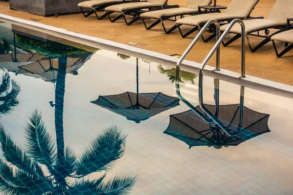 Güzel lüks otel ve tatil seyahat ve tatil için sandalye ve şemsiye ile açık yüzme havuzu