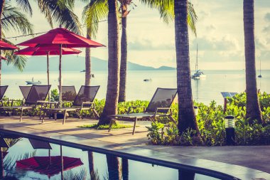 Güzel lüks otel ve tatil seyahat ve tatil için sandalye ve şemsiye ile açık yüzme havuzu