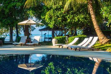 Güzel lüks otel ve tatil seyahat ve tatil için sandalye ve şemsiye ile açık yüzme havuzu