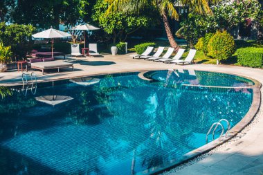 Güzel lüks otel ve tatil seyahat ve tatil için sandalye ve şemsiye ile açık yüzme havuzu