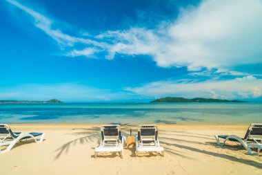 Güzel tropikal plaj ve Hindistan cevizi hurma ağacı ve Cennet Adası sandalyede denize sıfır