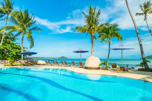 Umbrella and chair around swimming pool in hotel and resort for travel and vacation