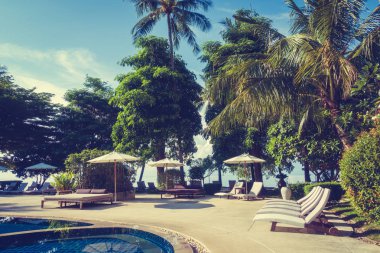 Güzel lüks otel ve tatil seyahat ve tatil için sandalye ve şemsiye ile açık yüzme havuzu