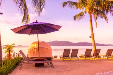 Şemsiye ve lüks otel ve gündoğumu zaman seyahat ve tatil için Resort'ta yüzme havuzu etrafında sandalye ile güzel açık görünüm