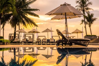 Güzel lüks otel ve tatil seyahat ve tatil için sandalye ve şemsiye ile açık yüzme havuzu