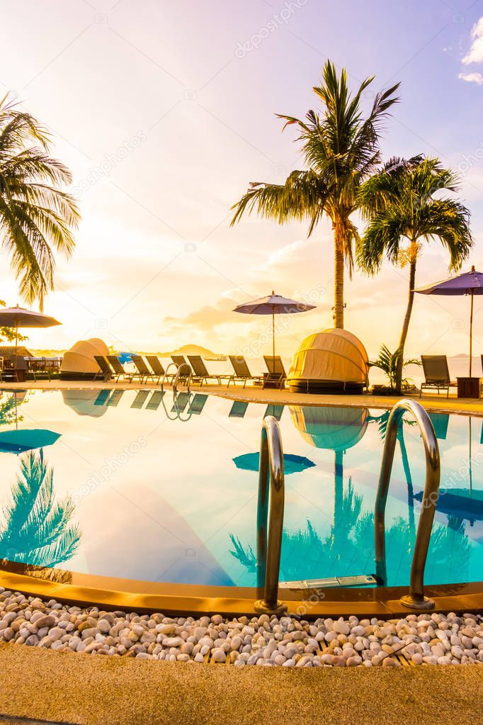 Beautiful outdoor view with umbrella and chair around swimming pool in luxury hotel and resort at sunrise time for travel and vacation