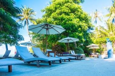 Güzel lüks otel ve tatil seyahat ve tatil için sandalye ve şemsiye ile açık yüzme havuzu