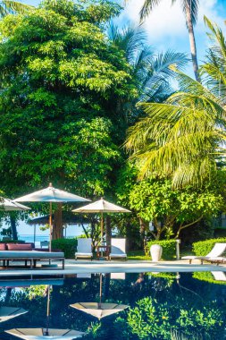 Güzel lüks otel ve tatil seyahat ve tatil için sandalye ve şemsiye ile açık yüzme havuzu