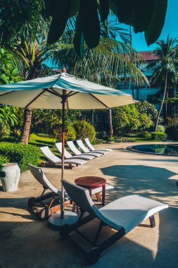 Güzel lüks otel ve tatil seyahat ve tatil için sandalye ve şemsiye ile açık yüzme havuzu