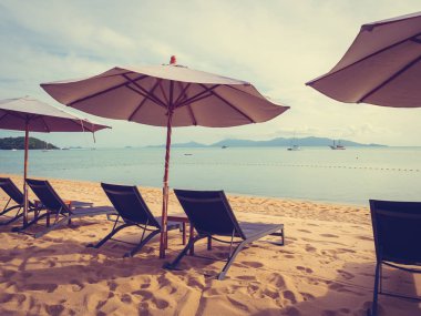 Şemsiye ve tropikal plaj deniz ve okyanus gündoğumu zaman seyahat ve tatil için sandalye