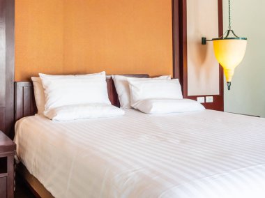 Otel yatak odasında ışık lamba dekorasyonu ile yatakta rahat yastık