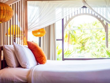 Otel yatak odasında ışık lamba dekorasyonu ile yatakta rahat yastık