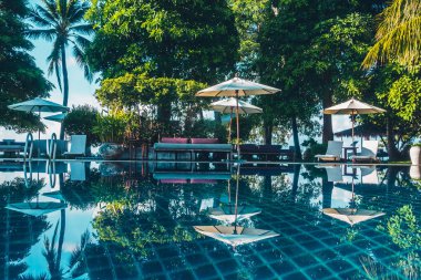 Güzel lüks otel ve tatil seyahat ve tatil için sandalye ve şemsiye ile açık yüzme havuzu