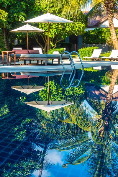 Güzel lüks otel ve tatil seyahat ve tatil için sandalye ve şemsiye ile açık yüzme havuzu