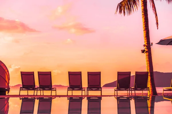 Şemsiye ve lüks otel ve gündoğumu zaman seyahat ve tatil için Resort'ta yüzme havuzu etrafında sandalye ile güzel açık görünüm