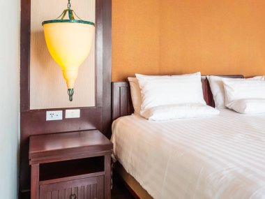 Otel yatak odasında ışık lamba dekorasyonu ile yatakta rahat yastık