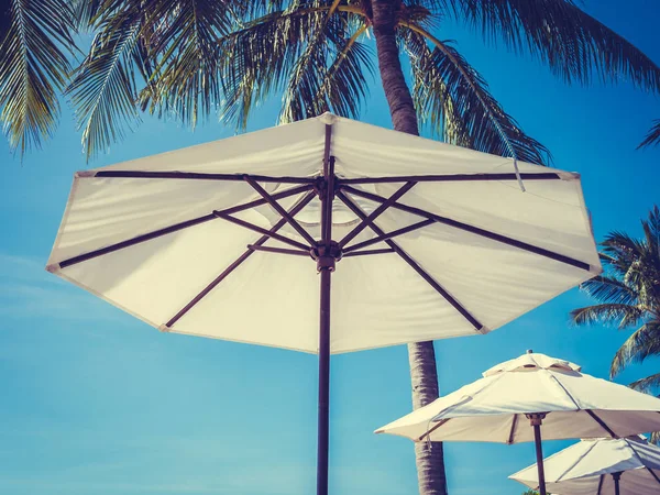 Hindistan cevizi hurma ağacı ile deniz okyanus seyahat ve tatil için mavi gökyüzü arka plan üzerinde Beyaz şemsiye