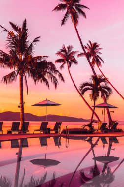 Şemsiye ve lüks otel ve gündoğumu zaman seyahat ve tatil için Resort'ta yüzme havuzu etrafında sandalye ile güzel açık görünüm