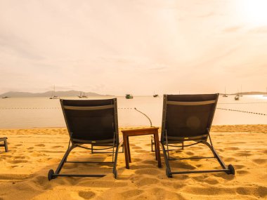 Şemsiye ve tropikal plaj deniz ve okyanus gündoğumu zaman seyahat ve tatil için sandalye