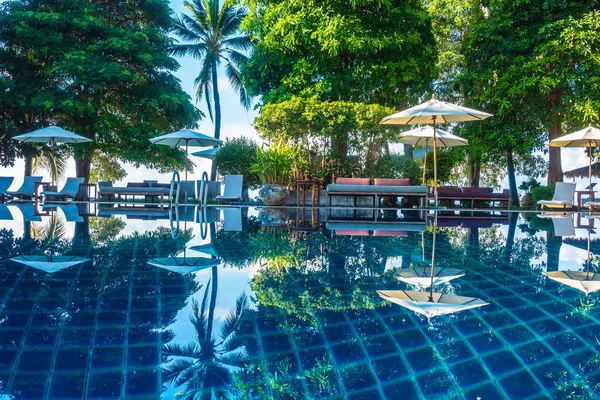 Güzel lüks otel ve tatil seyahat ve tatil için sandalye ve şemsiye ile açık yüzme havuzu