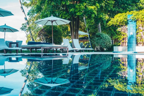 Güzel lüks otel ve tatil seyahat ve tatil için sandalye ve şemsiye ile açık yüzme havuzu