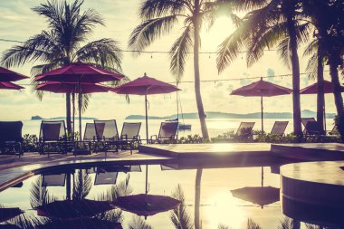 Güzel lüks otel ve tatil seyahat ve tatil için sandalye ve şemsiye ile açık yüzme havuzu