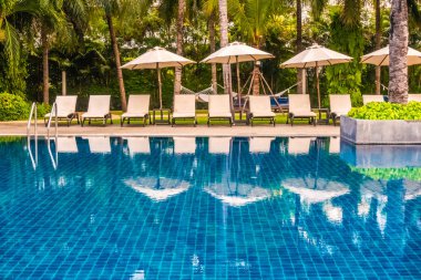 Güzel lüks otel ve tatil seyahat ve tatil için sandalye ve şemsiye ile açık yüzme havuzu