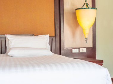 Otel yatak odasında ışık lamba dekorasyonu ile yatakta rahat yastık