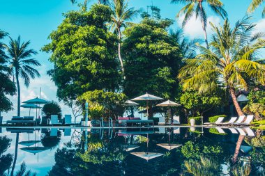 Güzel lüks otel ve tatil seyahat ve tatil için sandalye ve şemsiye ile açık yüzme havuzu