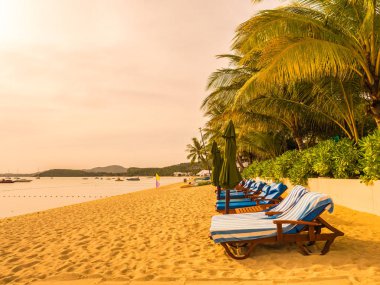Şemsiye ve tropikal plaj deniz ve okyanus gündoğumu zaman seyahat ve tatil için sandalye