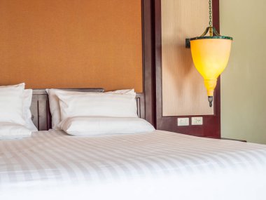 Otel yatak odasında ışık lamba dekorasyonu ile yatakta rahat yastık