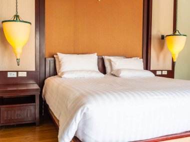 Otel yatak odasında ışık lamba dekorasyonu ile yatakta rahat yastık