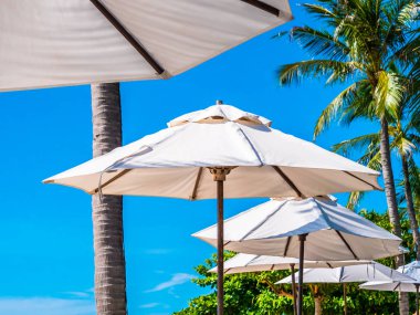 Hindistan cevizi hurma ağacı ile deniz okyanus seyahat ve tatil için mavi gökyüzü arka plan üzerinde Beyaz şemsiye