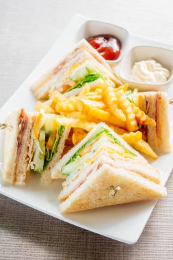 Club sandviç pastırma peynir, jambon sebze ve sos beyaz plaka ile