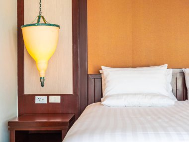 Otel yatak odasında ışık lamba dekorasyonu ile yatakta rahat yastık