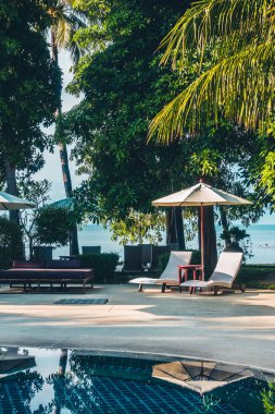 Güzel lüks otel ve tatil seyahat ve tatil için sandalye ve şemsiye ile açık yüzme havuzu