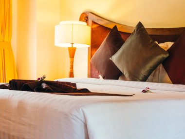 Otel yatak odasında ışık lamba dekorasyonu ile yatakta rahat yastık