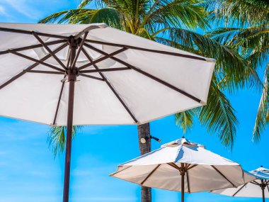 Hindistan cevizi hurma ağacı ile deniz okyanus seyahat ve tatil için mavi gökyüzü arka plan üzerinde Beyaz şemsiye