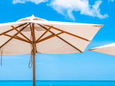 Hindistan cevizi hurma ağacı ile deniz okyanus seyahat ve tatil için mavi gökyüzü arka plan üzerinde Beyaz şemsiye