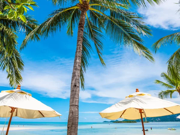 白色伞与椰棕榈树与海洋在蓝天背景为旅行和假期 — 图库照片
